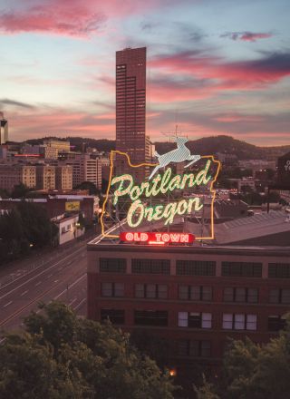 A cityscape featuring a neon sign that reads 